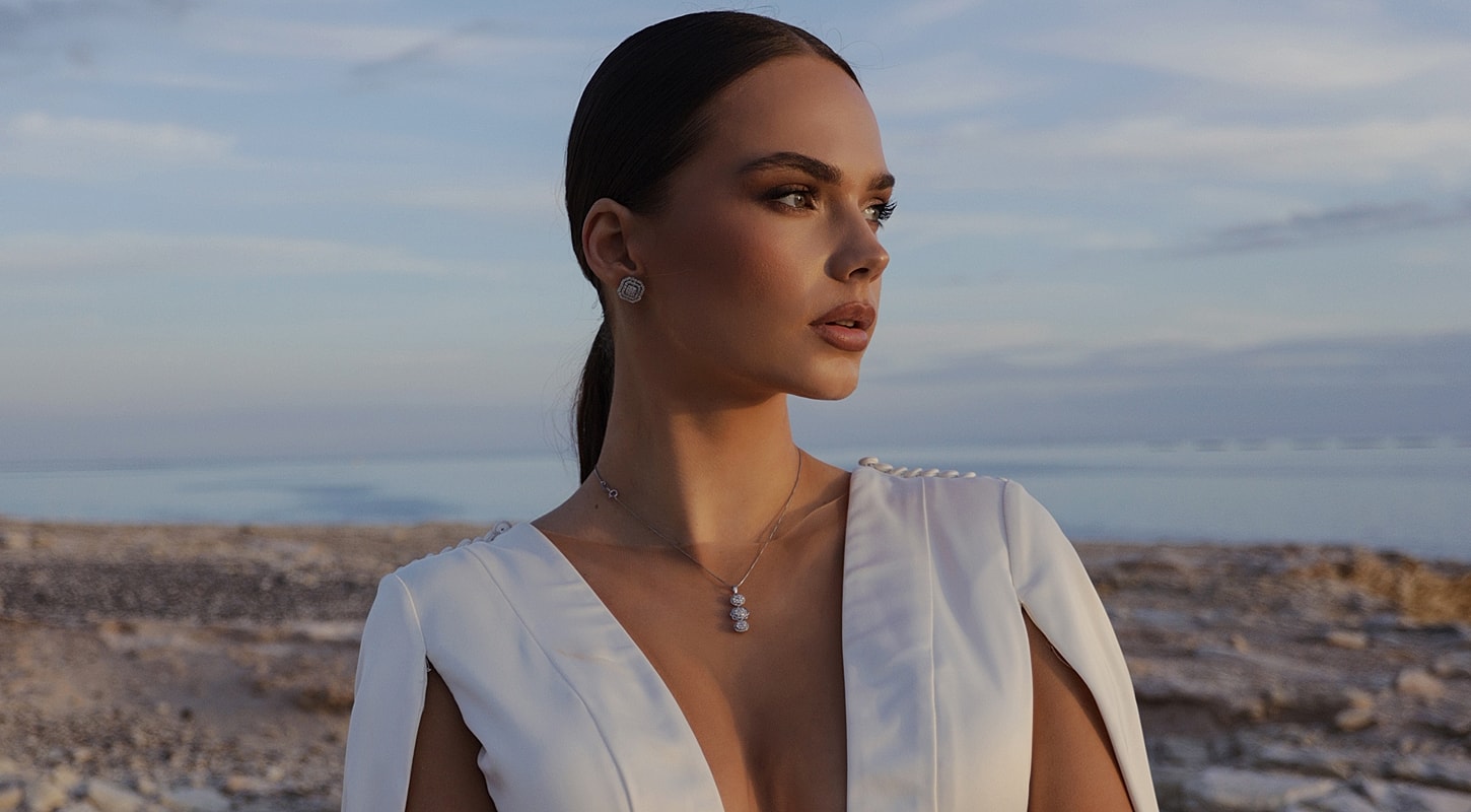 Woman in elegant dress by the sea at dusk.