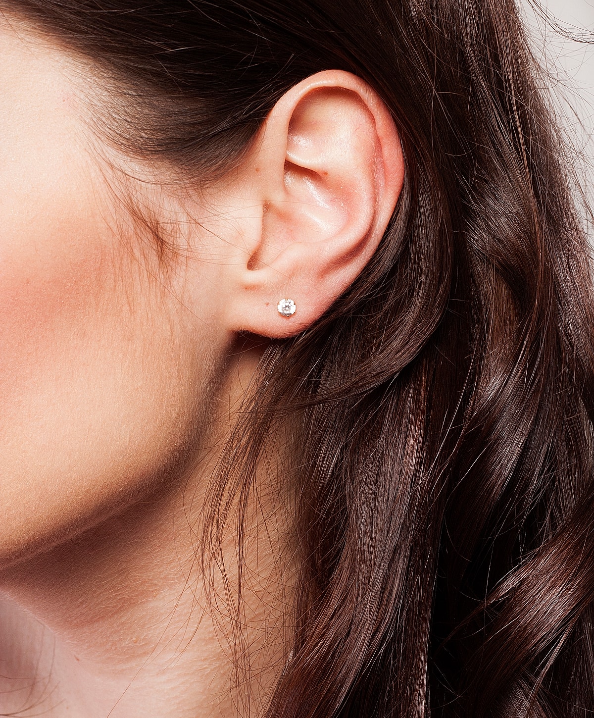 Close-up of ear with stud earring.