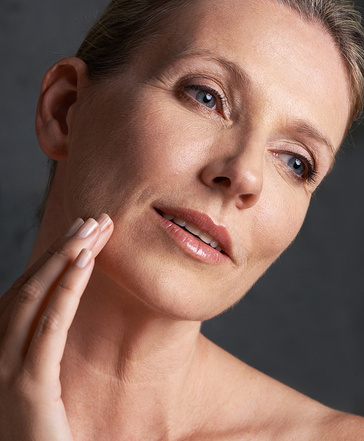 facelift patient model gently touching her face, natural beauty.