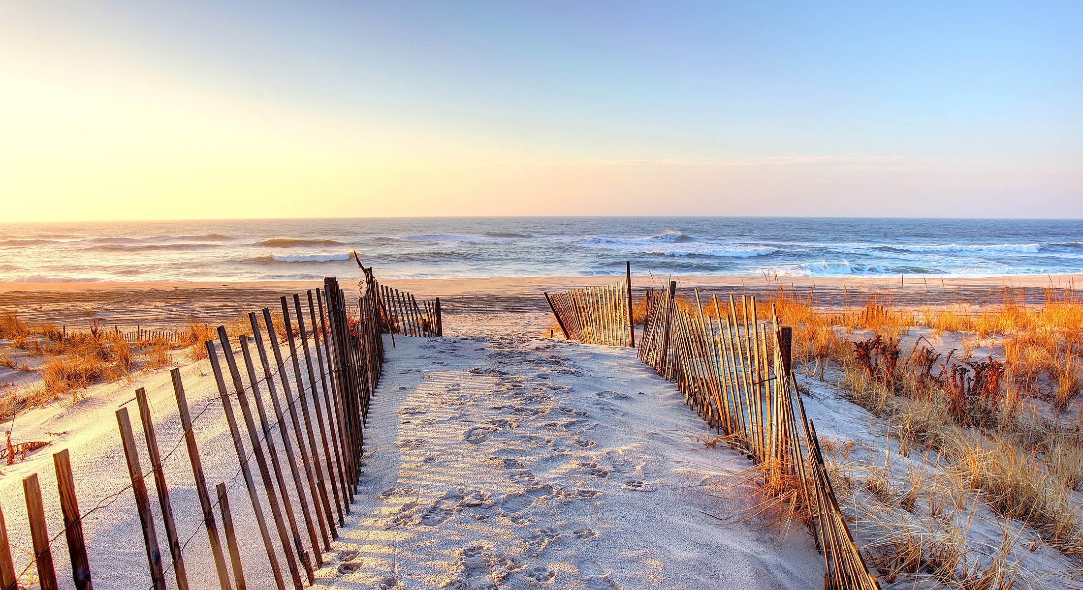 Pathway to a serene beach at sunset.