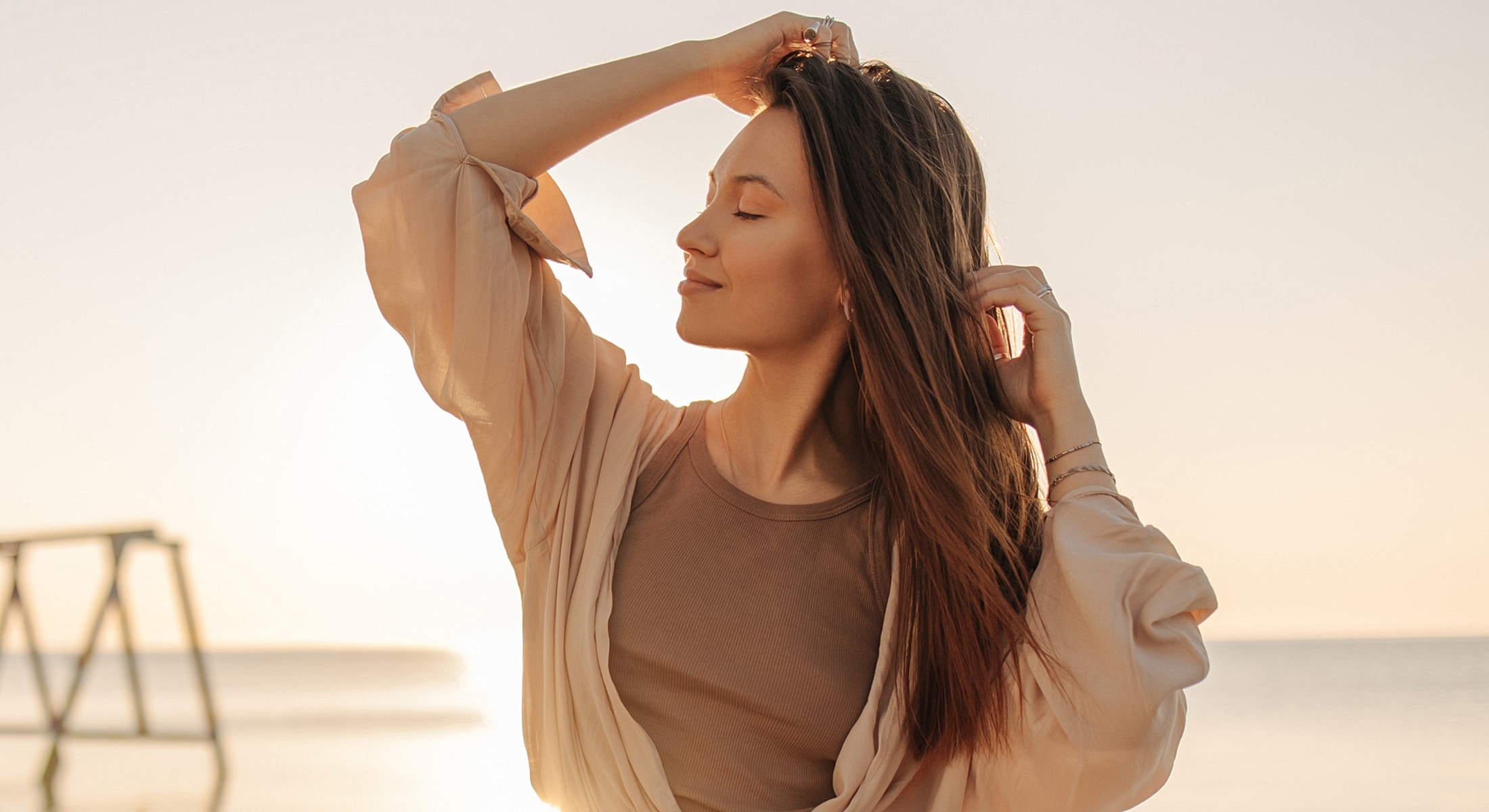 arm lift patient model enjoying sunset at the beach.